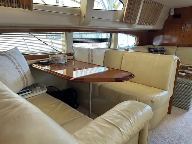 River Dancer Yacht Photos Pics Interior of 2004 Carver 466 Motor Yacht with cream leather seating and wooden table.