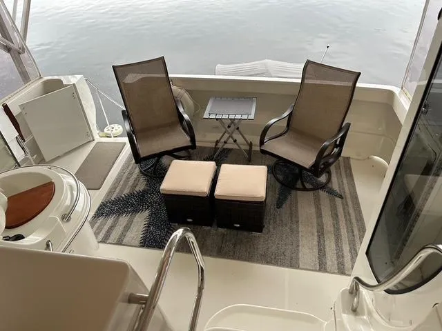 River Dancer Yacht Photos Pics 2004 Carver 466 Motor Yacht deck with chairs, table, and ottomans overlooking water.