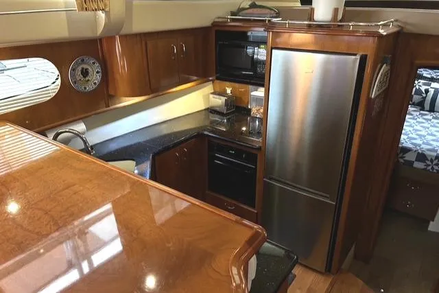 River Dancer Yacht Photos Pics Luxurious kitchen interior of 2004 Carver 466 Motor Yacht with wood cabinetry and modern appliances.