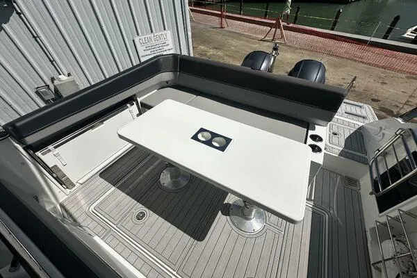 Keys Please! Yacht Photos Pics 2024 Jeanneau Leader 9.0 WA boat deck with seating and table, docked at marina.
