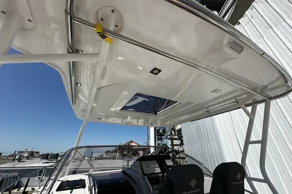 Keys Please! Yacht Photos Pics 2024 Jeanneau Leader 9.0 WA boat interior with helm and seating under a hardtop.