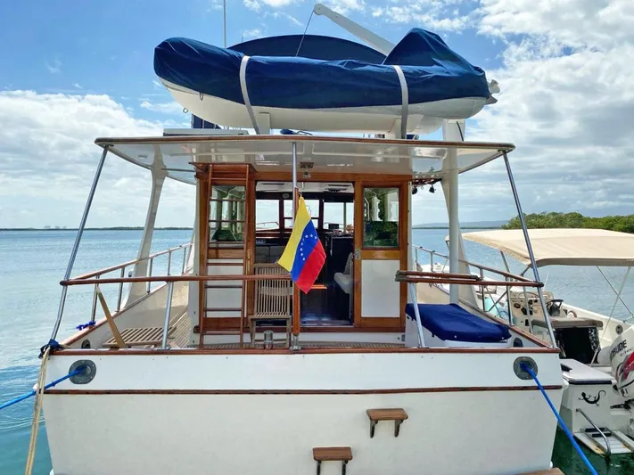  Yacht Photos Pics 1981 Grand Banks 42 Europa yacht with Venezuelan flag, docked by the water.