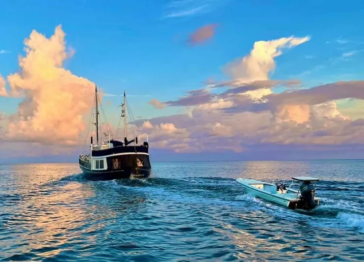 Ursa Minor Yacht Photos Pics Kadey-Krogen 54 yacht on serene ocean at sunset, 1988 model, with vibrant sky and clouds.
