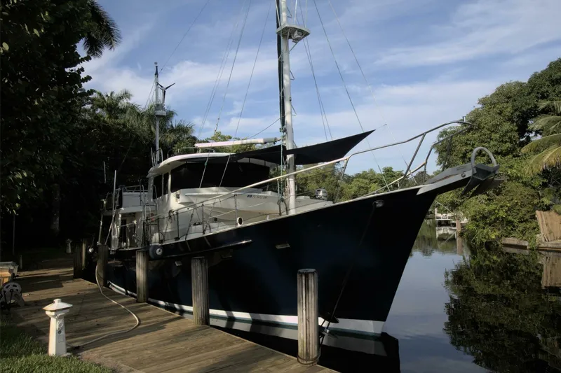 Ursa Minor Yacht Photos Pics 1988 Kadey-Krogen Krogen 54 yacht docked by lush greenery and calm waters.