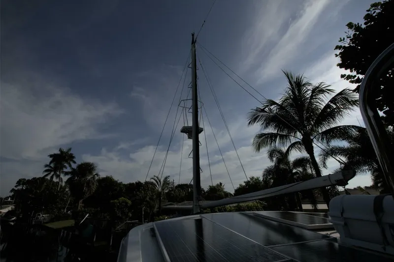 Ursa Minor Yacht Photos Pics 1988 Kadey-Krogen Krogen 54 yacht mast with palm trees and cloudy sky.