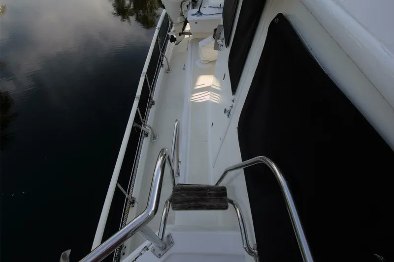 Ursa Minor Yacht Photos Pics Side deck of 1988 Kadey-Krogen Krogen 54 yacht with railing and water reflection.