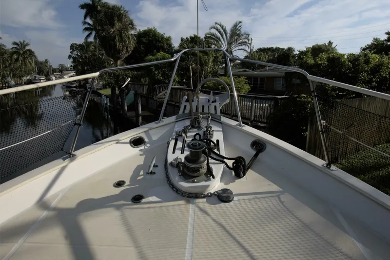 Ursa Minor Yacht Photos Pics Bow view of 1988 Kadey-Krogen Krogen 54 yacht, docked near lush greenery.