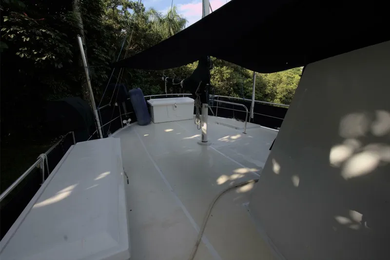 Ursa Minor Yacht Photos Pics 1988 Kadey-Krogen Krogen 54 yacht deck with canopy, surrounded by lush greenery.