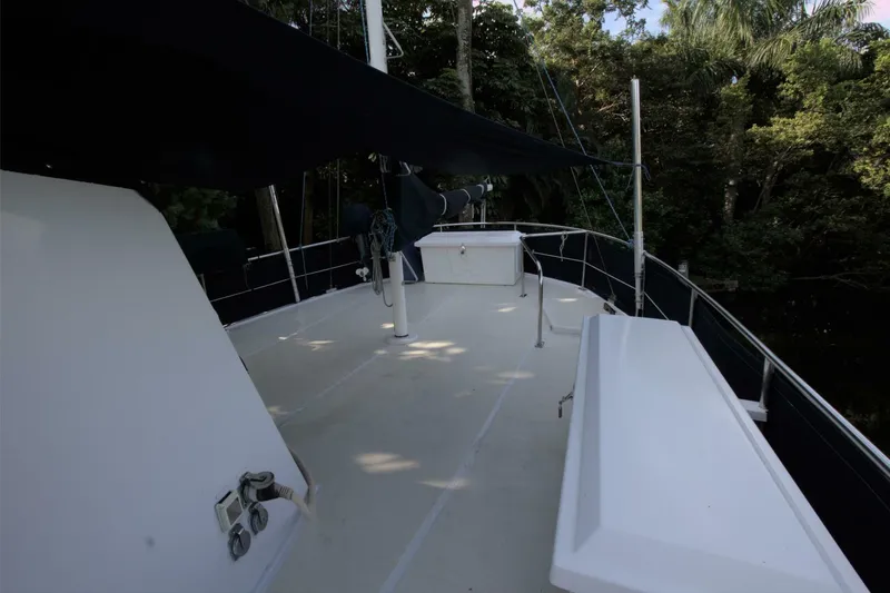 Ursa Minor Yacht Photos Pics 1988 Kadey-Krogen Krogen 54 yacht deck with canopy and seating, surrounded by lush greenery.