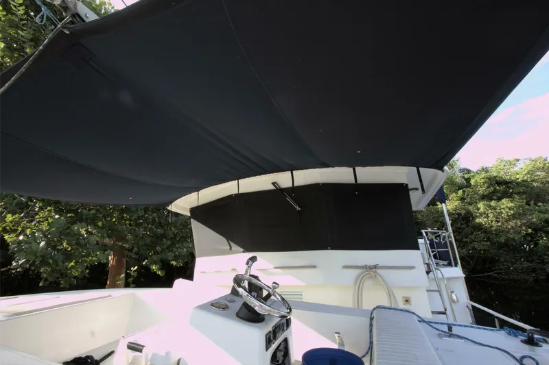 Ursa Minor Yacht Photos Pics 1988 Kadey-Krogen Krogen 54 yacht helm with canopy, surrounded by lush greenery.