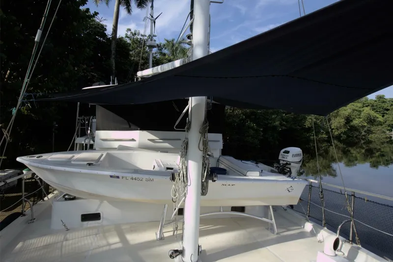 Ursa Minor Yacht Photos Pics 1988 Kadey-Krogen Krogen 54 yacht with dinghy and canopy, docked near lush greenery.