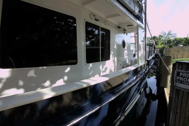 Ursa Minor Yacht Photos Pics 1988 Kadey-Krogen Krogen 54 yacht docked beside a wooden fence.