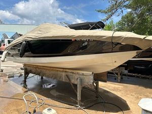 2011 Chaparral 216 SSi boat covered and elevated on a stand outdoors.