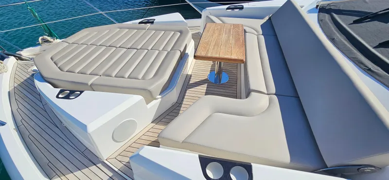  Yacht Photos Pics Luxurious seating area on 2019 Sunseeker Manhattan 66 yacht with elegant wooden table.