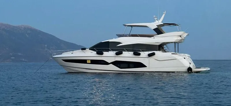  Yacht Photos Pics 2019 Sunseeker Manhattan 66 yacht on calm water with mountainous backdrop.