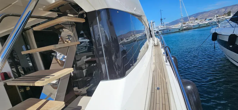  Yacht Photos Pics 2019 Sunseeker Manhattan 66 yacht docked, showcasing sleek design and wooden deck.