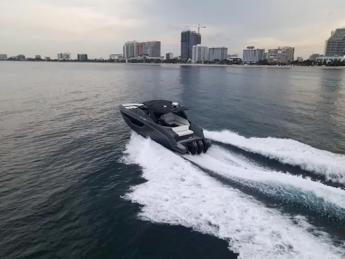 Di Blue Yacht Photos Pics 2022 Cruisers Yachts 38 GLS speeding on water near city skyline.