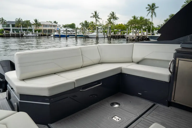 Di Blue Yacht Photos Pics 2022 Cruisers Yachts 38 GLS with luxurious seating, docked by waterfront homes and palm trees.