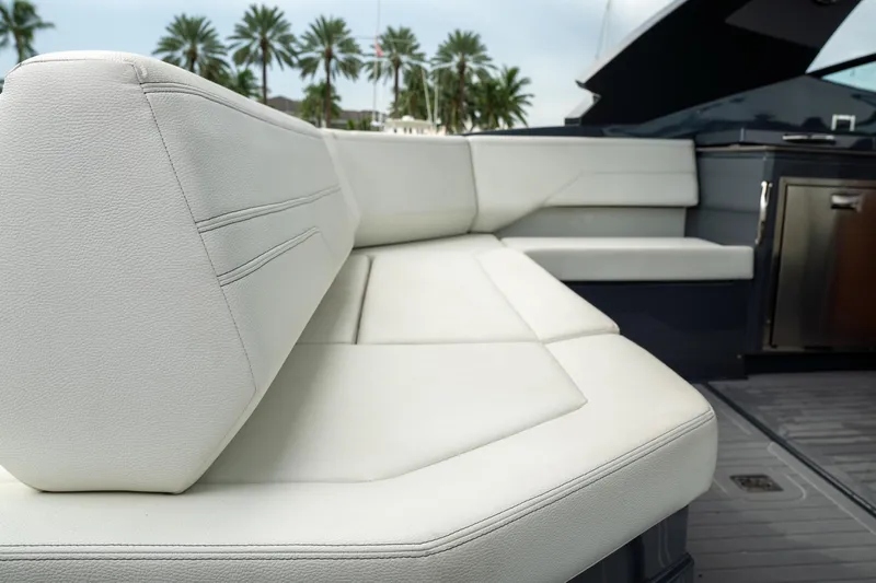 Di Blue Yacht Photos Pics 2022 Cruisers Yachts 38 GLS interior with white seating and palm trees in the background.