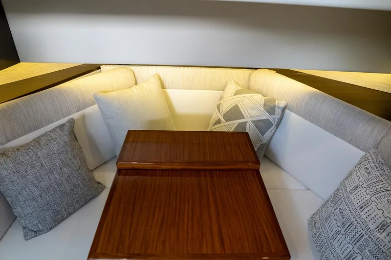 Di Blue Yacht Photos Pics 2022 Cruisers Yachts 38 GLS interior with cushioned seating and wooden table.