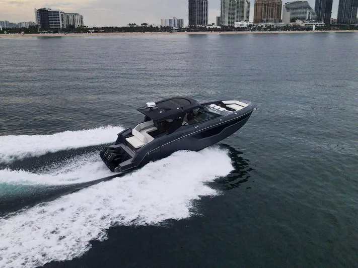 Di Blue Yacht Photos Pics 2022 Cruisers Yachts 38 GLS speeding on water near city skyline.