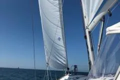 Maelstrom Yacht Photos Pics Sailing on a 2017 Beneteau Oceanis 45 yacht with white sails against a clear blue sky.