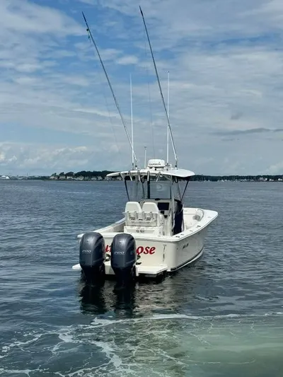  Yacht Photos Pics 2015 Regulator 25 boat with dual engines on calm water under a cloudy sky.