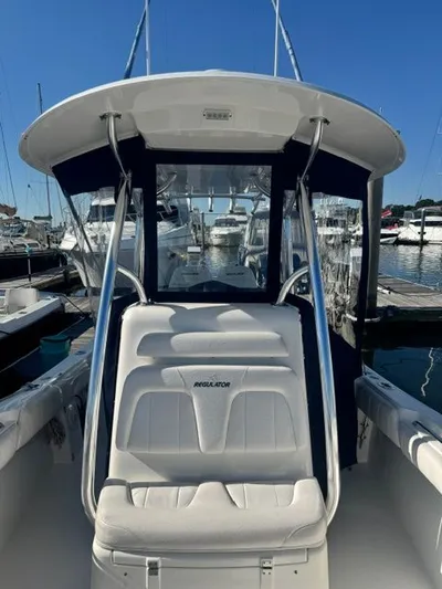  Yacht Photos Pics 2015 Regulator 25 boat with white seating, docked at a marina under clear blue skies.