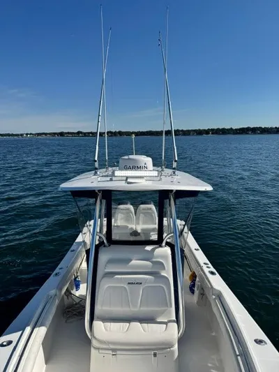  Yacht Photos Pics 2015 Regulator 25 boat on calm water with Garmin equipment, clear sky background.