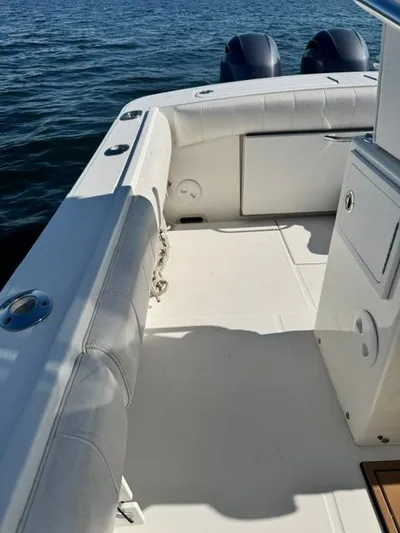  Yacht Photos Pics 2015 Regulator 25 boat interior with cushioned seating and dual engines on water.