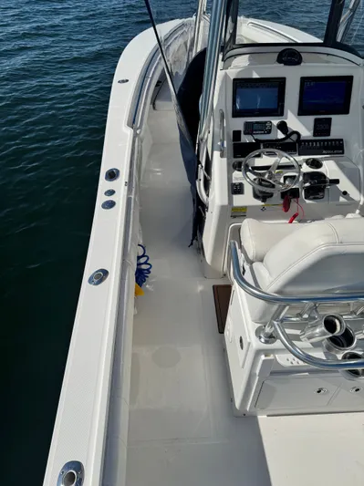  Yacht Photos Pics 2015 Regulator 25 boat cockpit with steering wheel and navigation screens on calm water.