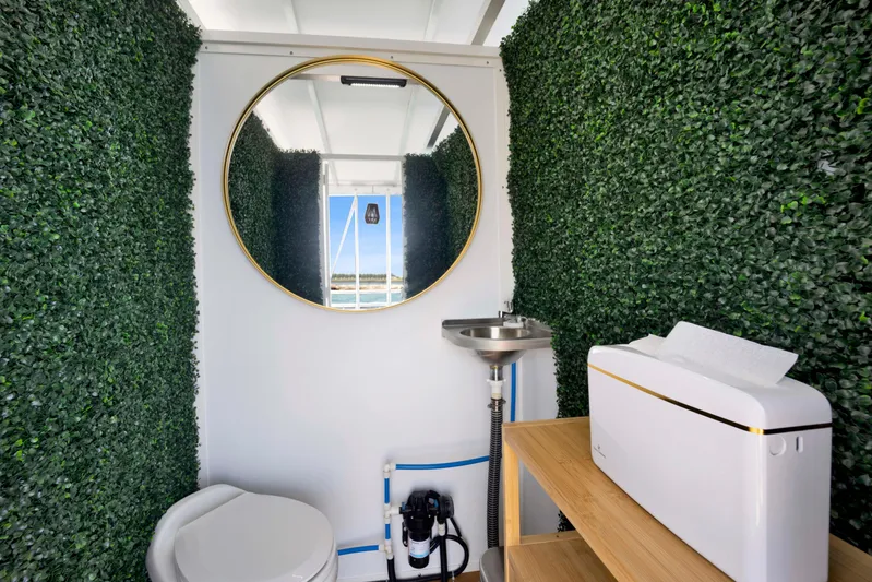  Yacht Photos Pics Modern bathroom with greenery walls, round mirror, and compact fixtures, A&M Manufacturing COI 2026 model.