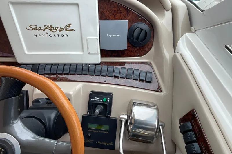 Club Level Yacht Photos Pics Control panel of a 2002 Sea Ray 480 Motor Yacht with wooden steering wheel.