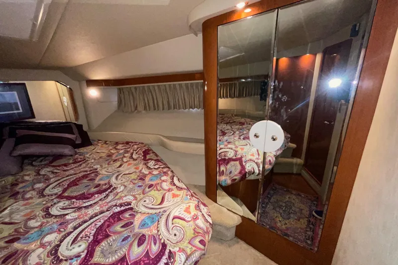 Club Level Yacht Photos Pics Luxurious 2002 Sea Ray 480 Motor Yacht bedroom with mirrored closet and vibrant bedding.