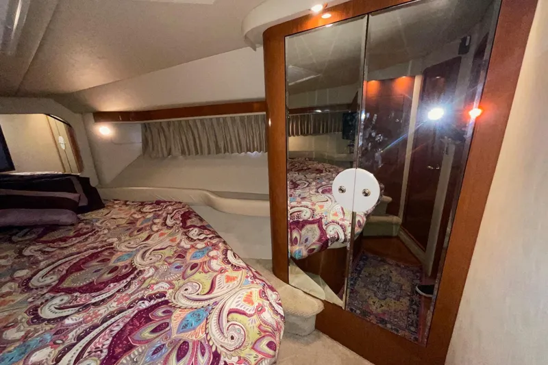 Club Level Yacht Photos Pics Luxurious 2002 Sea Ray 480 Motor Yacht bedroom with mirrored closet and patterned bedding.