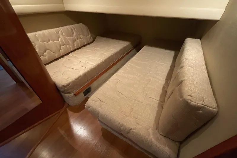 Club Level Yacht Photos Pics 2002 Sea Ray 480 Motor Yacht interior with beige cushioned seating and wooden flooring.