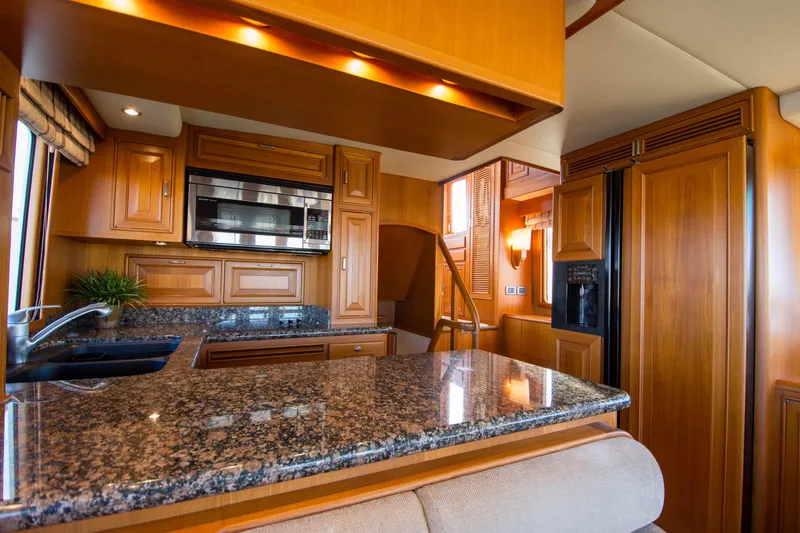  Yacht Photos Pics Luxurious kitchen interior of 2013 Fleming 55 yacht with granite countertops and wooden cabinetry.