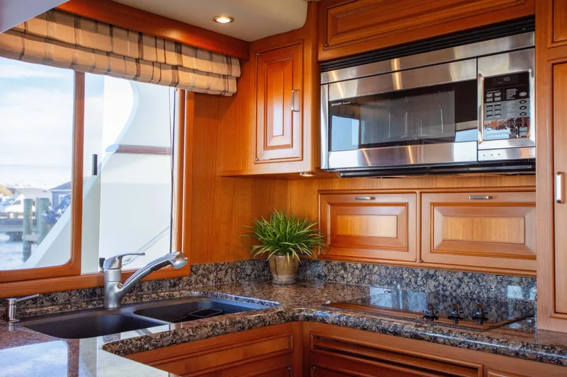  Yacht Photos Pics Luxurious kitchen interior of 2013 Fleming 55 yacht with granite countertops and stainless steel appliances.