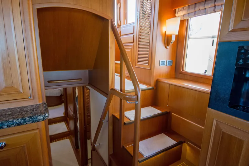  Yacht Photos Pics Luxurious wooden interior of a 2013 Fleming 55 yacht with elegant staircase and lighting.