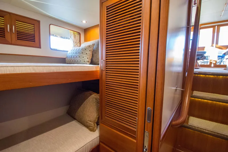  Yacht Photos Pics Luxurious cabin interior of 2013 Fleming 55 yacht with wooden finishes and cozy bedding.