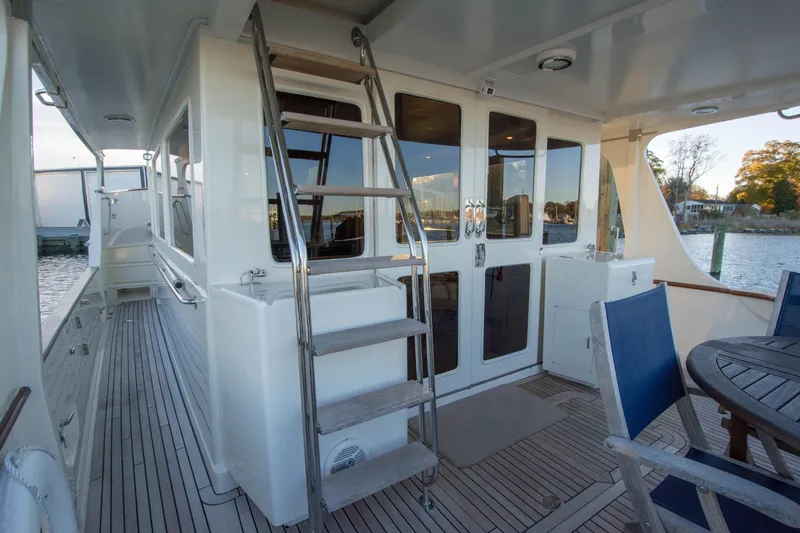  Yacht Photos Pics Luxurious 2013 Fleming 55 yacht deck with seating and ladder, docked by the water.