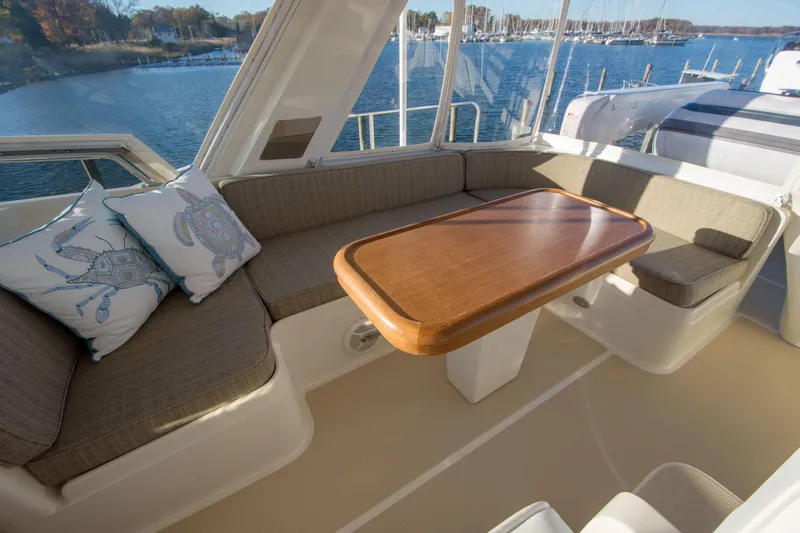  Yacht Photos Pics Luxurious 2013 Fleming 55 yacht interior with elegant seating and wooden table, overlooking serene waters.