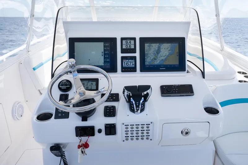  Yacht Photos Pics Control panel of a 2016 Intrepid 400 Cuddy boat with navigation screens and steering wheel.
