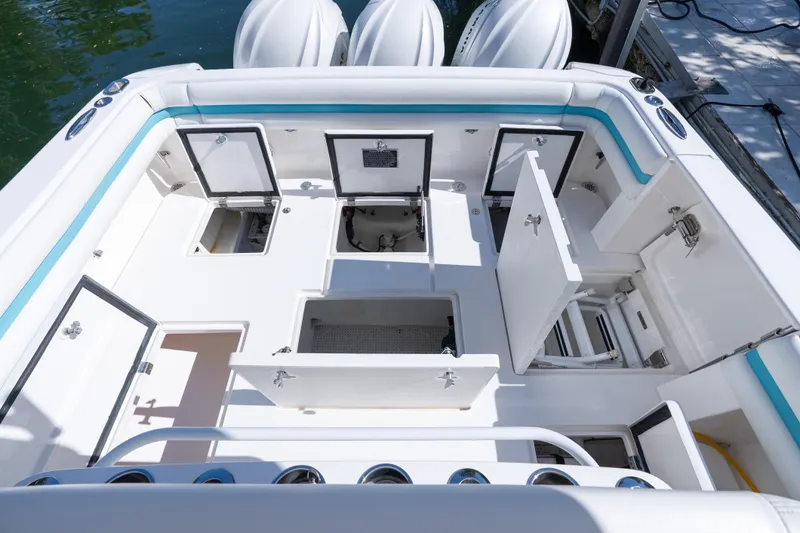  Yacht Photos Pics 2016 Intrepid 400 Cuddy boat deck with open storage compartments and visible engines.