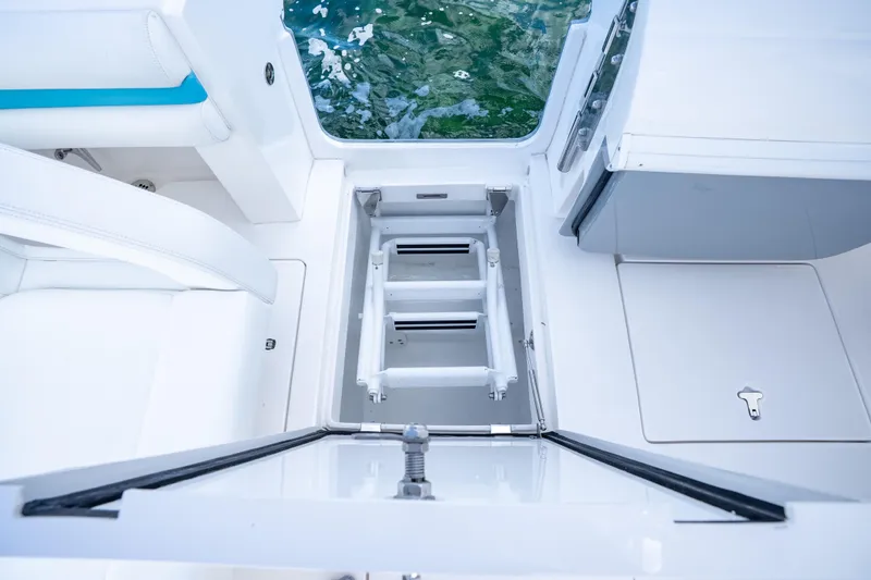  Yacht Photos Pics 2016 Intrepid 400 Cuddy boat interior with open hatch and ladder, near water.