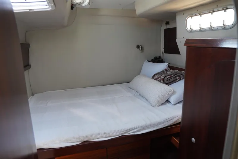 Loki Yacht Photos Pics Cozy cabin interior of 1995 Fountaine Pajot Venezia 42 catamaran with bed and porthole.