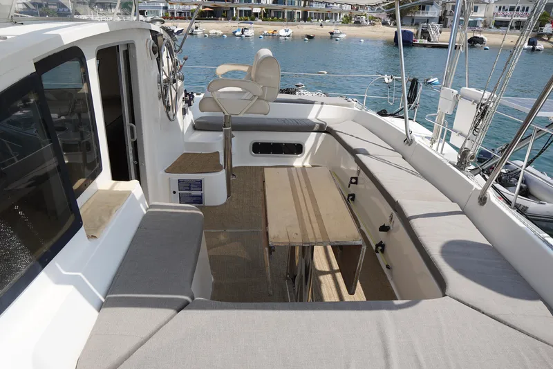 Loki Yacht Photos Pics Spacious deck of 1995 Fountaine Pajot Venezia 42 catamaran with seating and steering wheel.