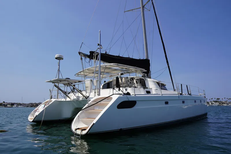 Loki Yacht Photos Pics Fountaine Pajot Venezia 42 catamaran, 1995 model, anchored on calm water under clear blue sky.