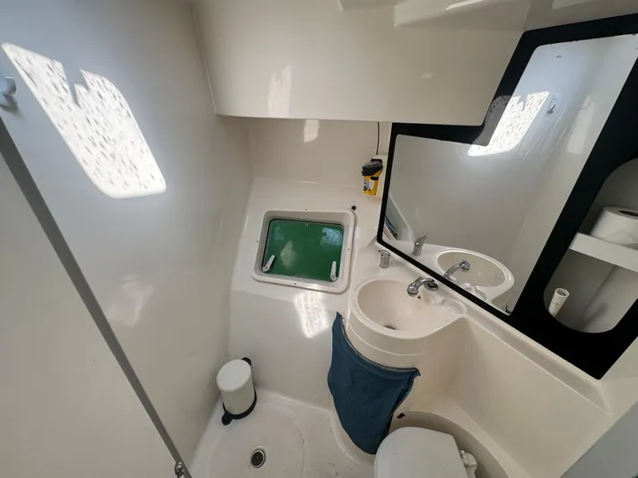 Loki Yacht Photos Pics Bathroom interior of 1995 Fountaine Pajot Venezia 42 catamaran, featuring sink, mirror, and window.