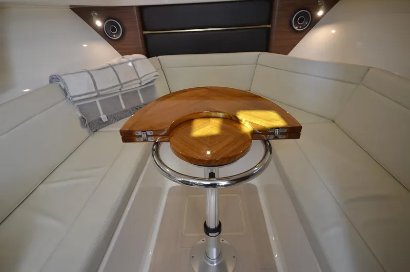  Yacht Photos Pics Manufacturer Provided Image: 2021 Boston Whaler 325 Conquest cabin interior with wooden table and white seating.